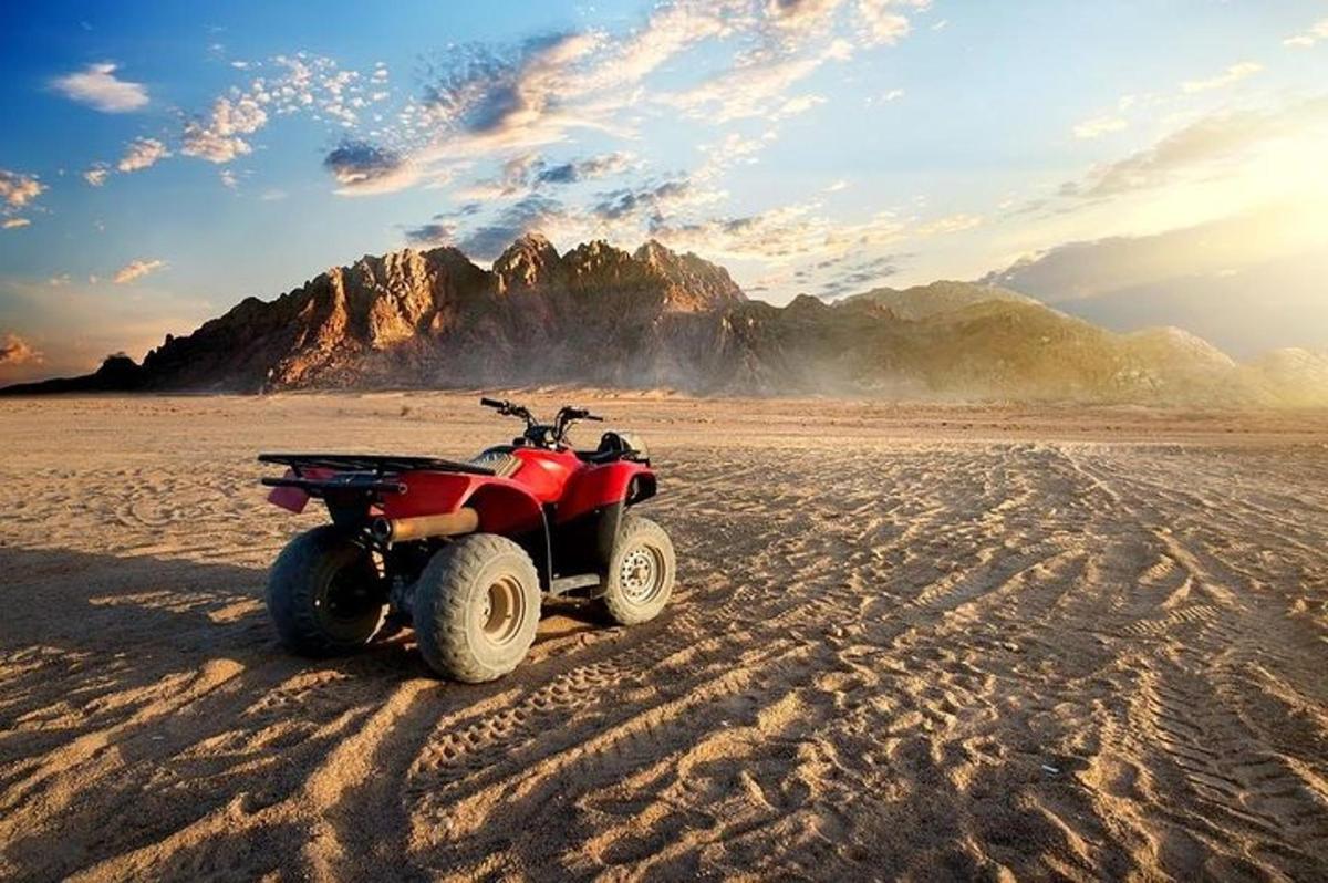 Ένα κόκκινο ATV παρκαρισμένο στην άμμο στην έρημο
