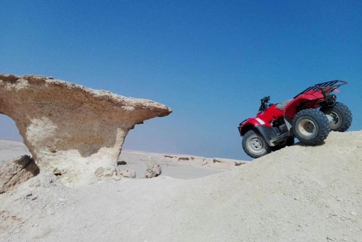 Ένα κόκκινο ATV στην άμμο στην έρημο