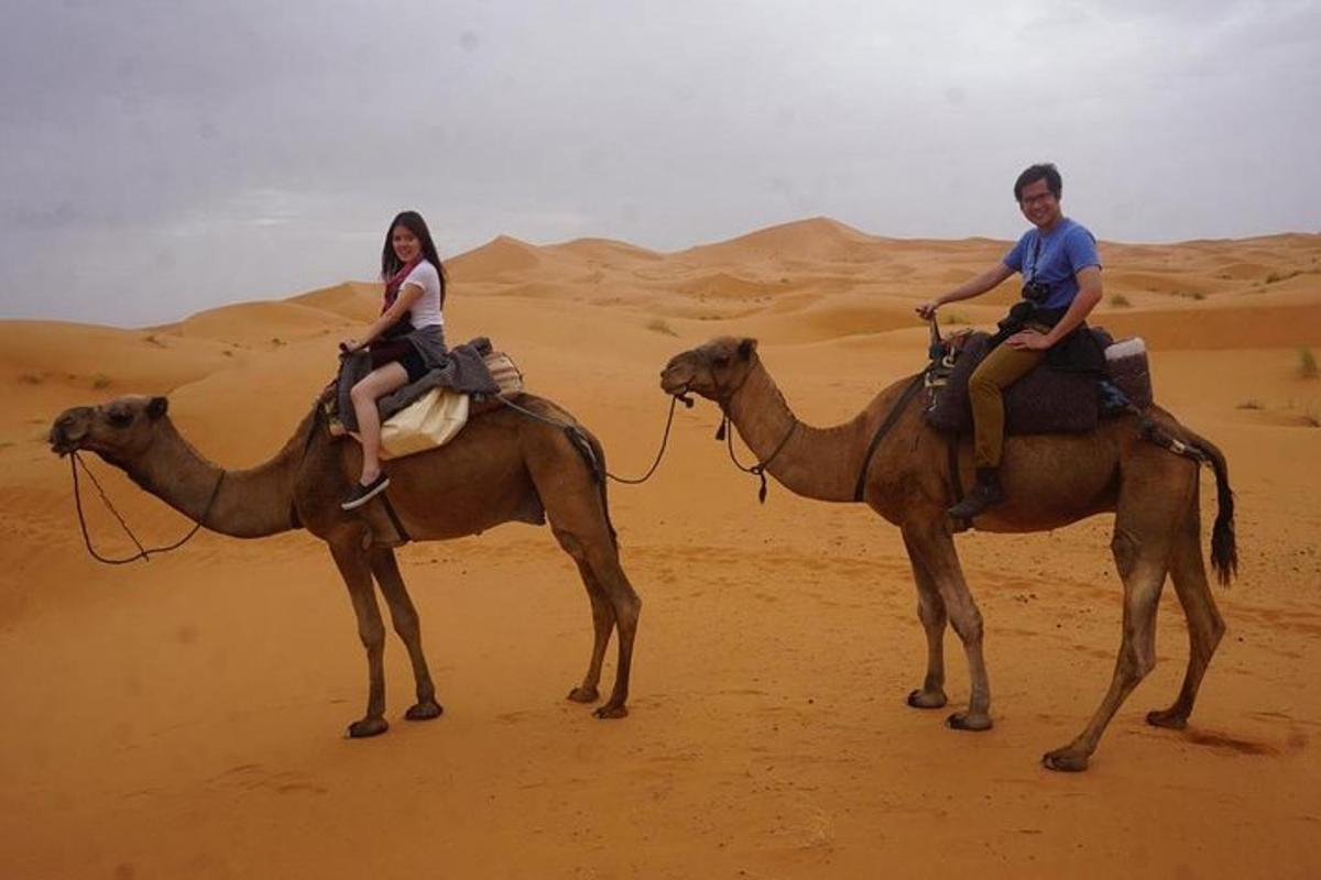 Dos personas montando a lomos de un camello en el desierto