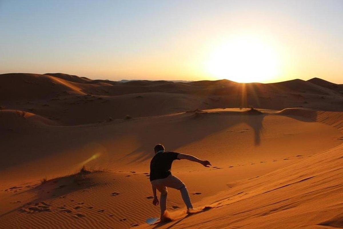 Un hombre en el desierto con el sol al fondo.