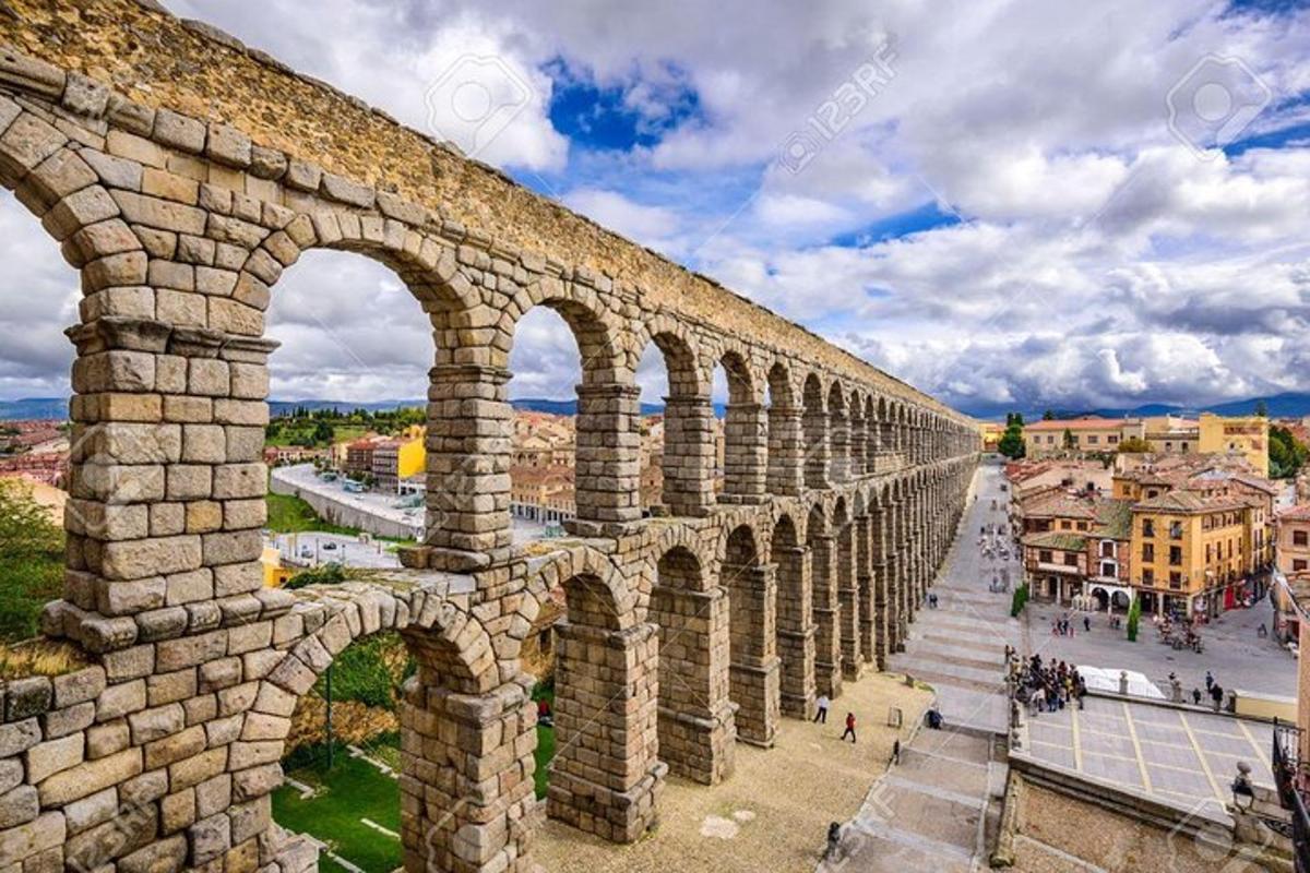 un antico acquedotto in una città in una giornata nuvolosa