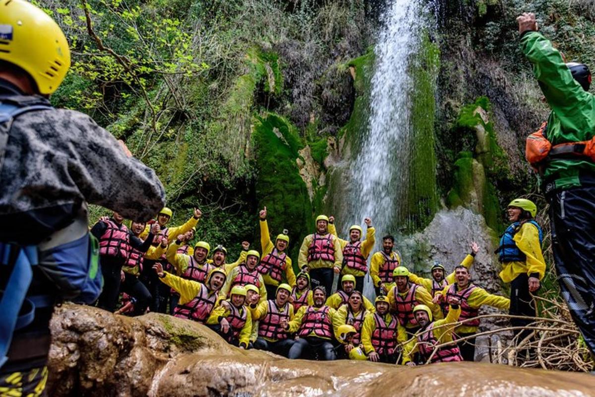 um grupo de pessoas posando para uma foto em frente a uma cachoeira