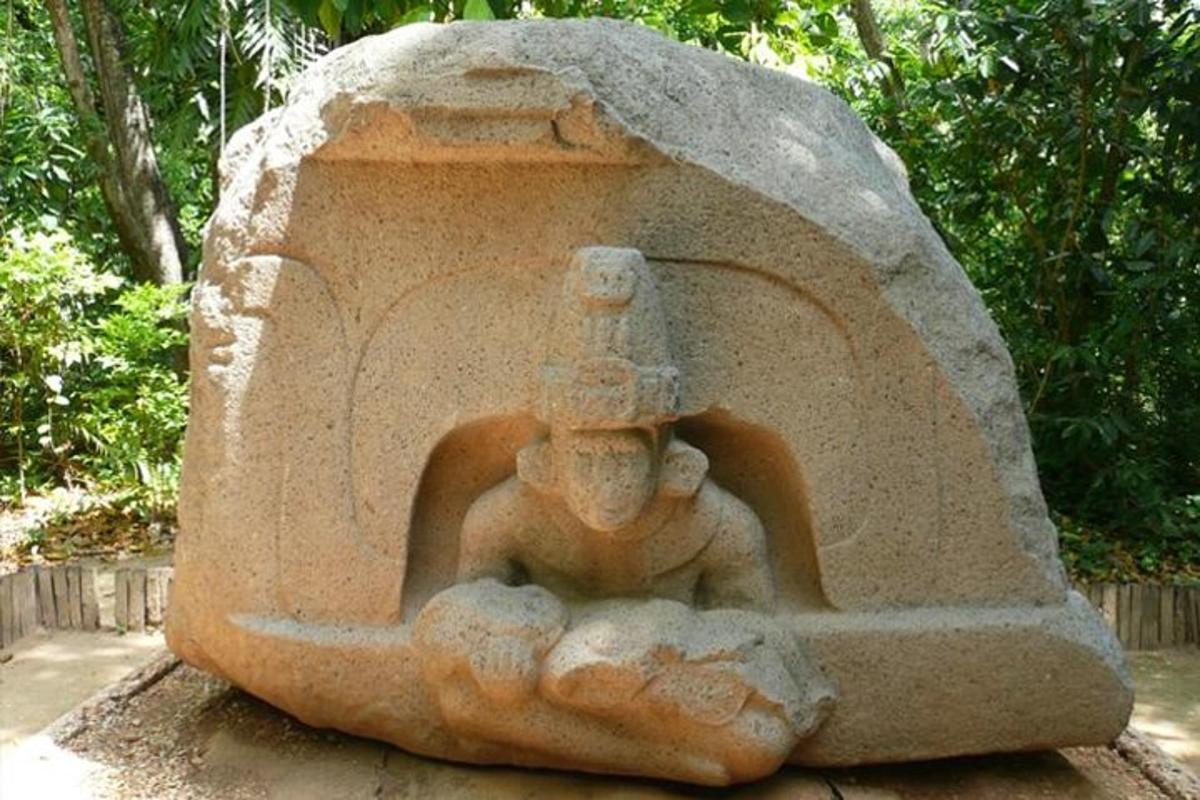 a statue of a man sitting on a rock