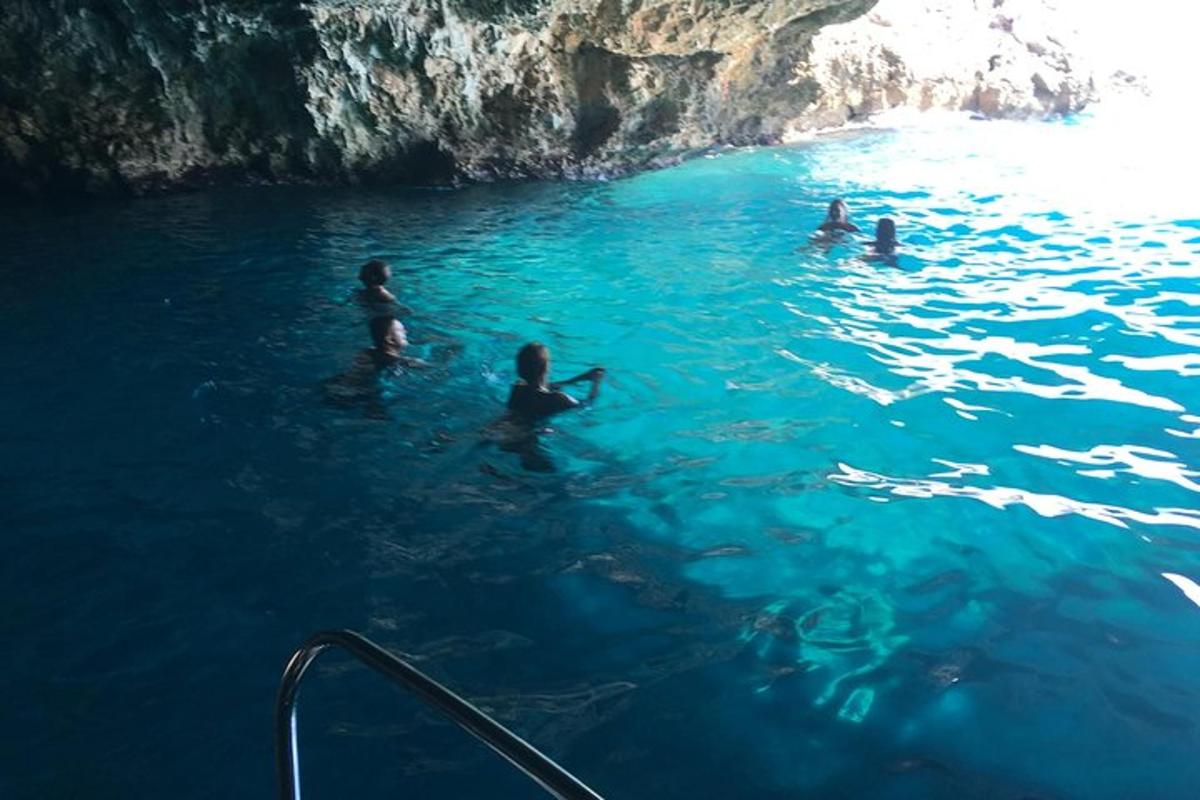 en grupp människor som simmar i en blå grotta