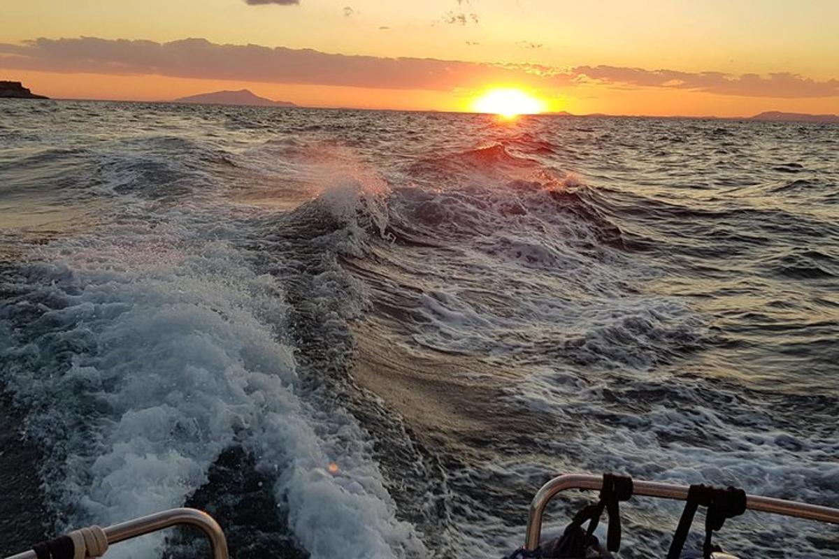 una barca nell'oceano con il tramonto sullo sfondo