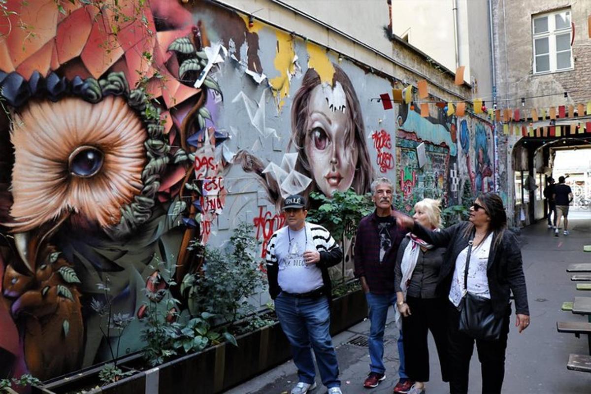 Un grupo de personas de pie frente a una pared con grafitis.