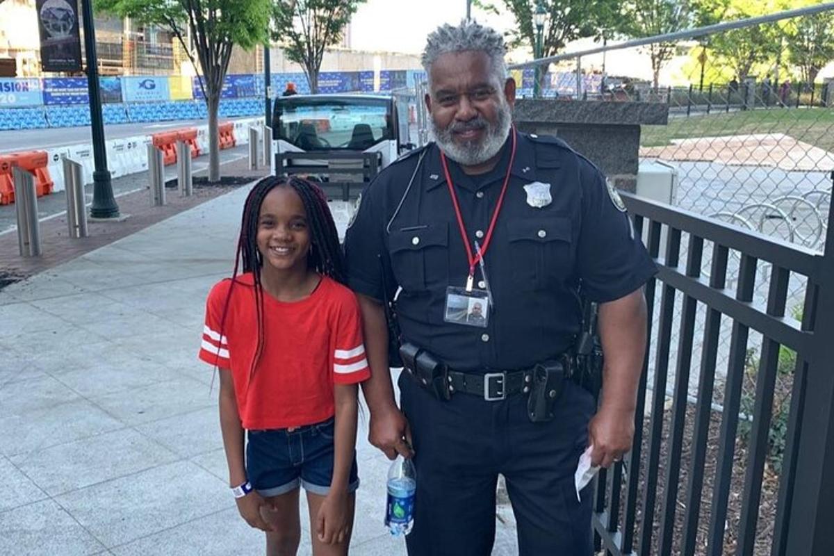 a man in uniform standing next to a little girl