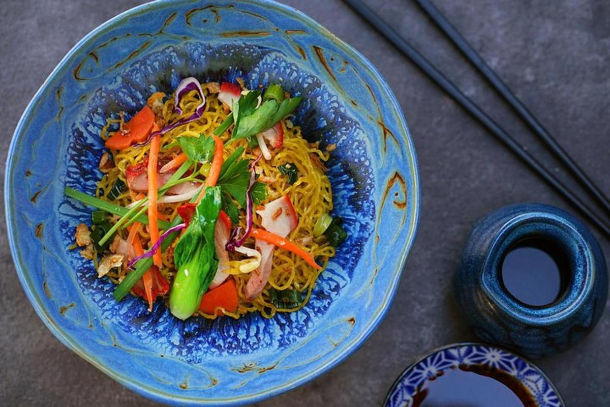 una ciotola blu di cibo con noodles e verdure
