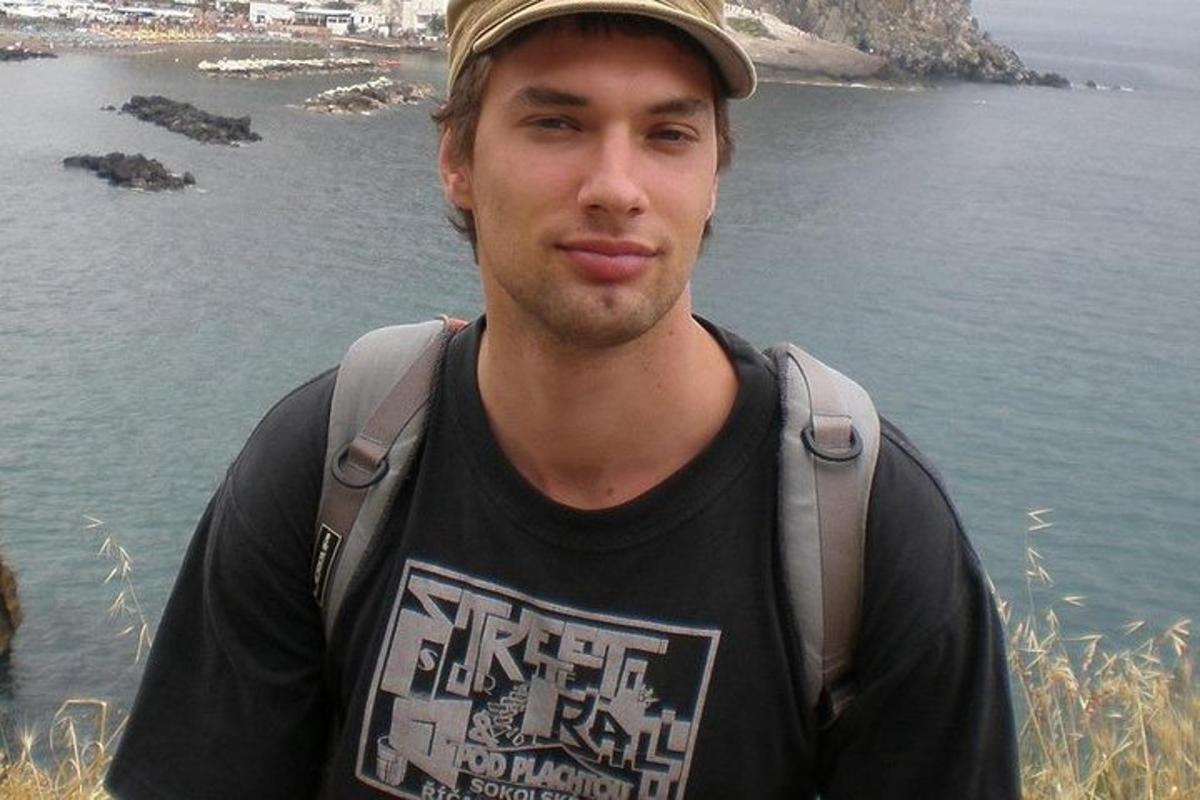 un uomo che indossa un cappello in piedi accanto all'acqua