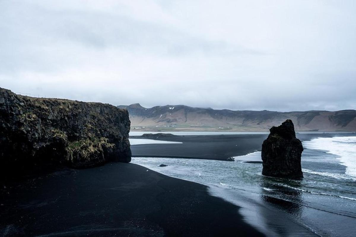 a black beach with two large rocks in the water
