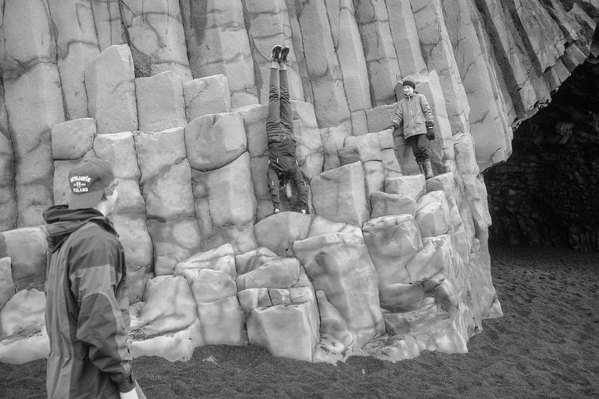 a man is standing in front of a rock wall