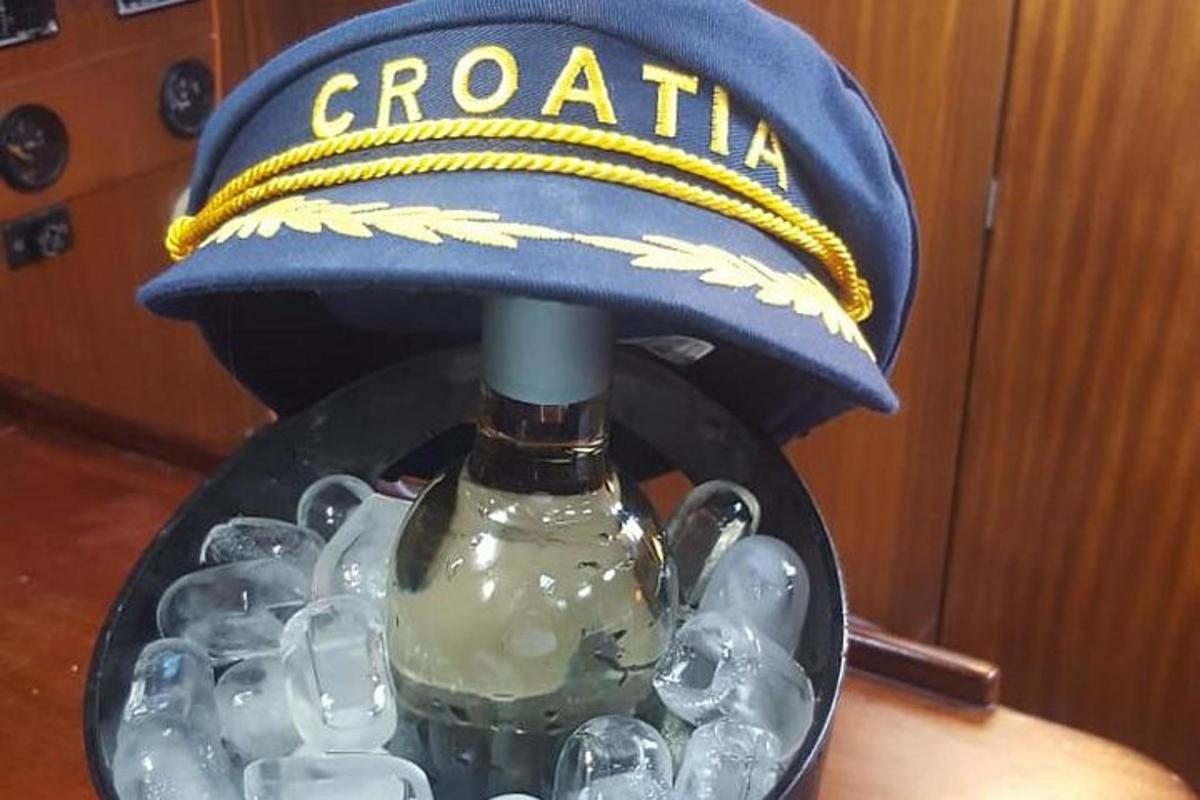 синій капітанський капелюх і пляшка на столі