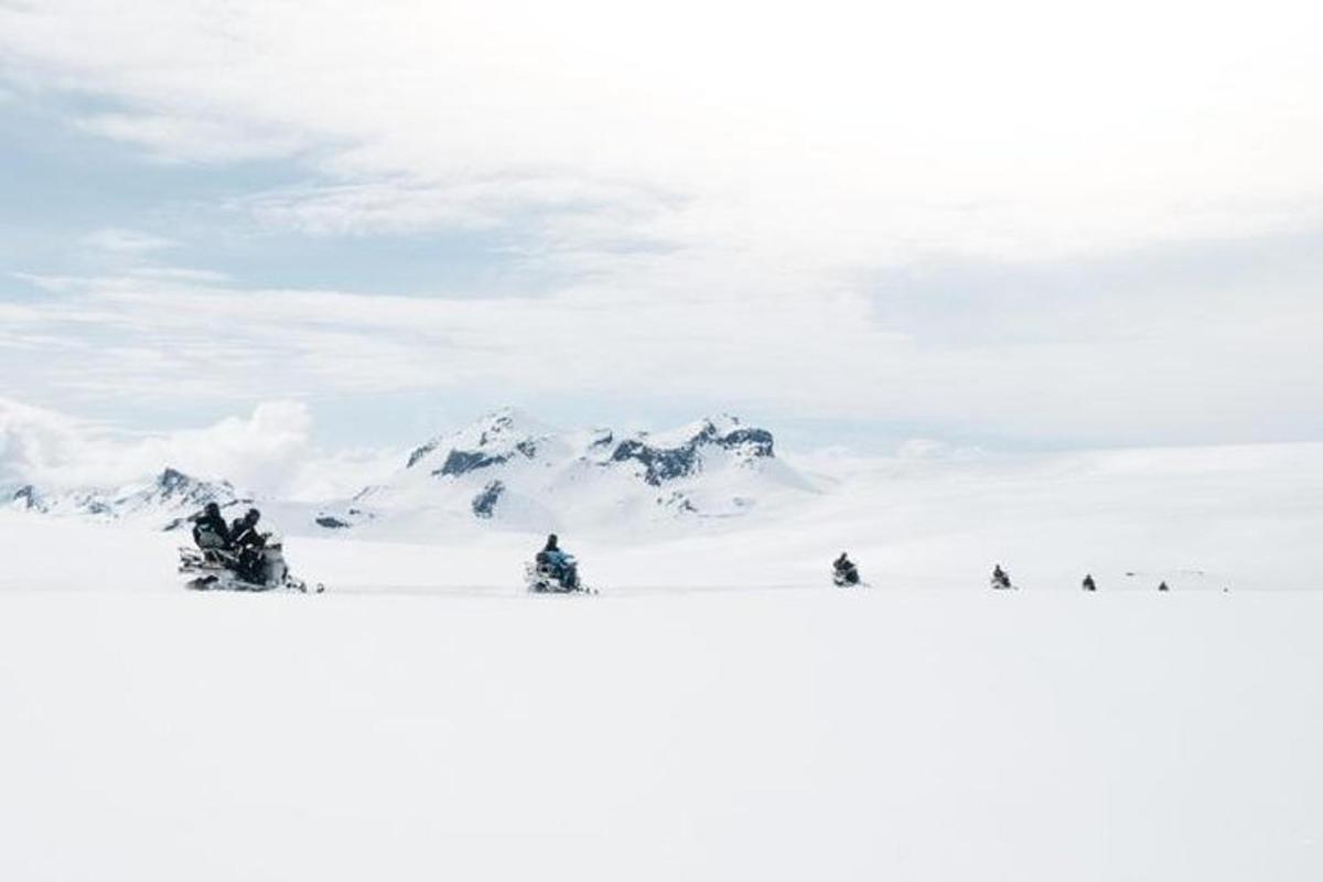 um grupo de pessoas no topo de uma montanha coberta de neve