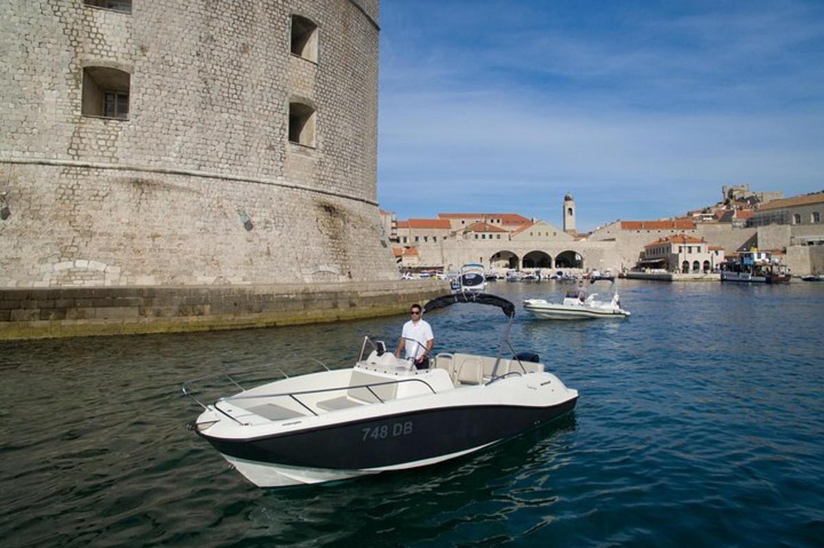 um homem em um barco na água perto de um castelo