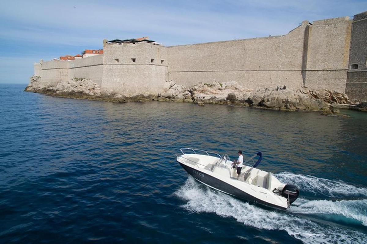 um homem em um barco na água perto de um castelo