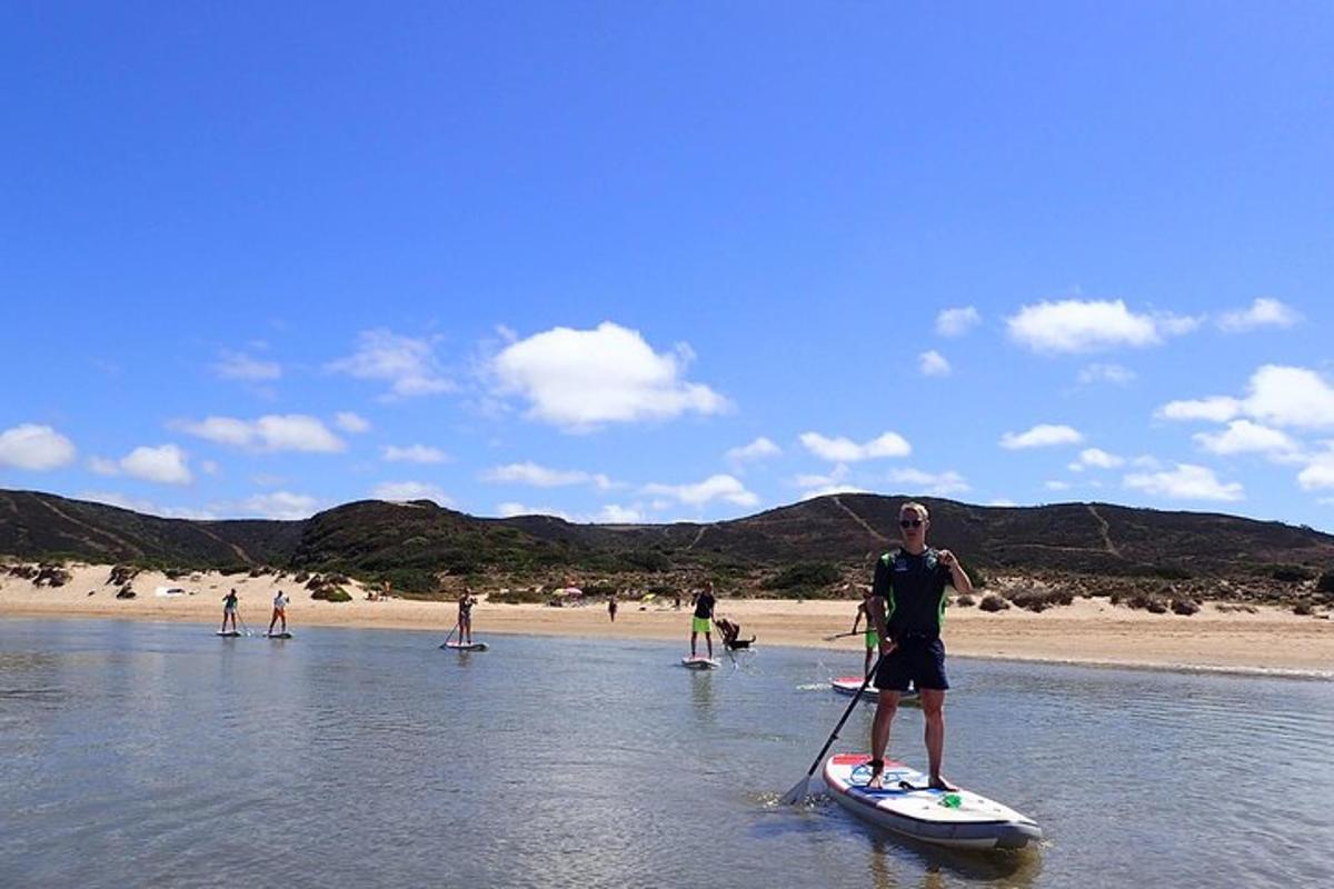 Muž stojí na paddleboardu ve vodě