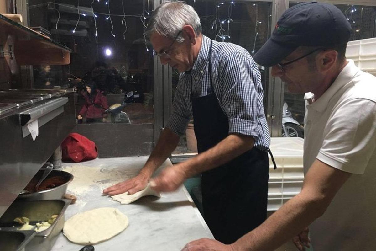 Dos hombres de pie en una cocina preparando comida