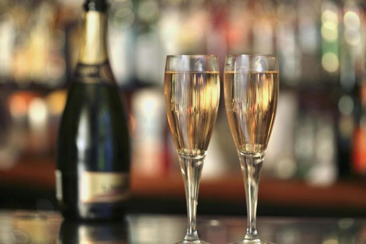 due bicchieri di champagne su un bar con una bottiglia di vino