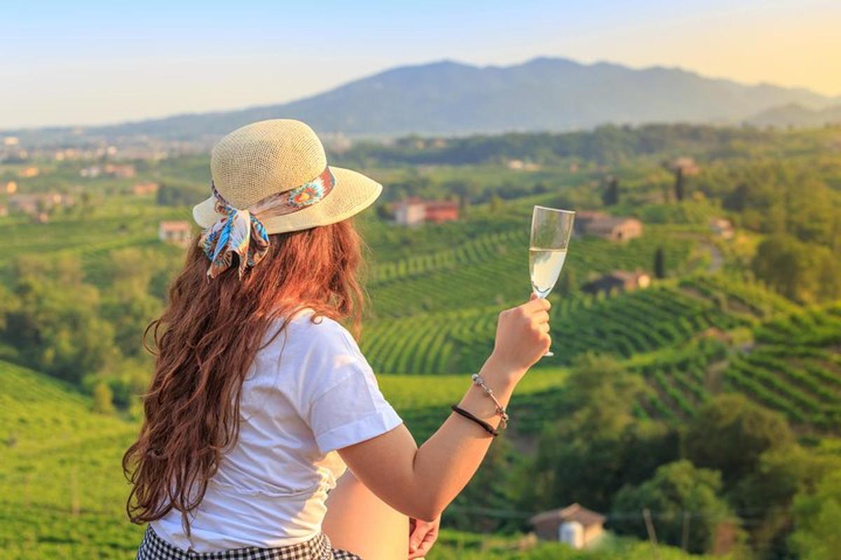 žena držící sklenici vína s výhledem na vinici