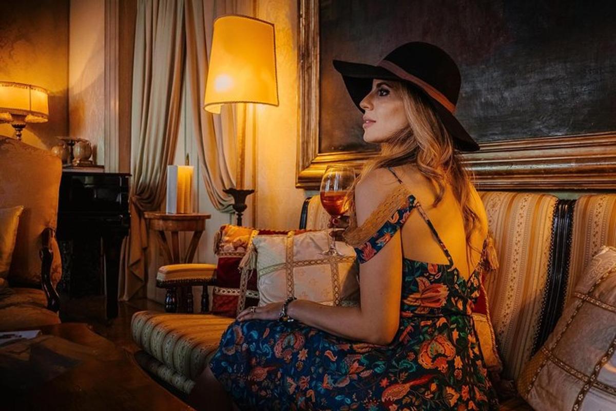 Una mujer sentada en un sofá sosteniendo una copa de vino.