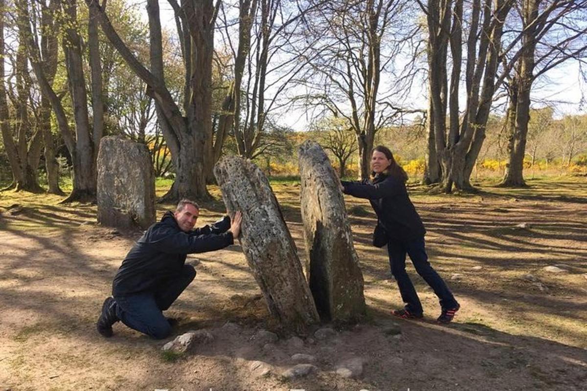 un uomo e una donna in piedi accanto a una scultura in pietra