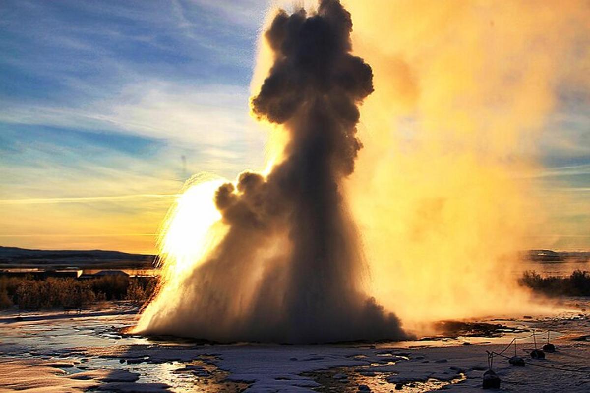 um gêiser em erupção no meio de um campo