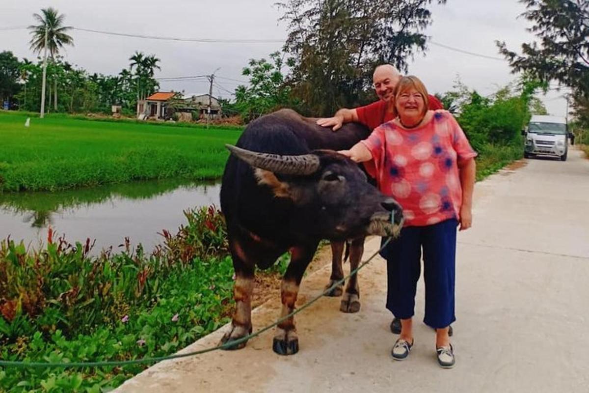 muž a žena stojící vedle krávy