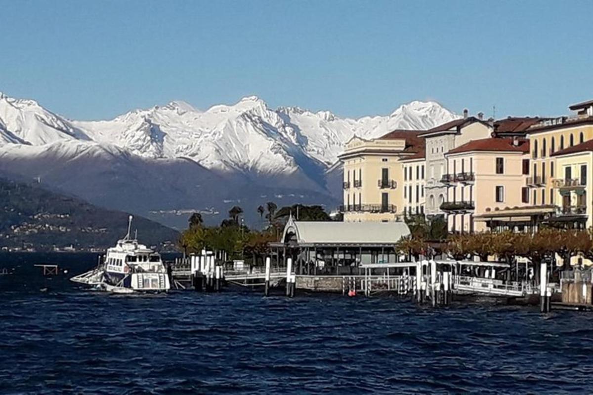 Un barco está atracado en un muelle con montañas cubiertas de nieve.
