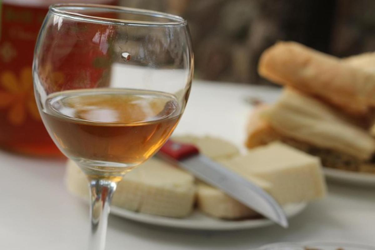una copa de vi al costat d'un plat de formatge