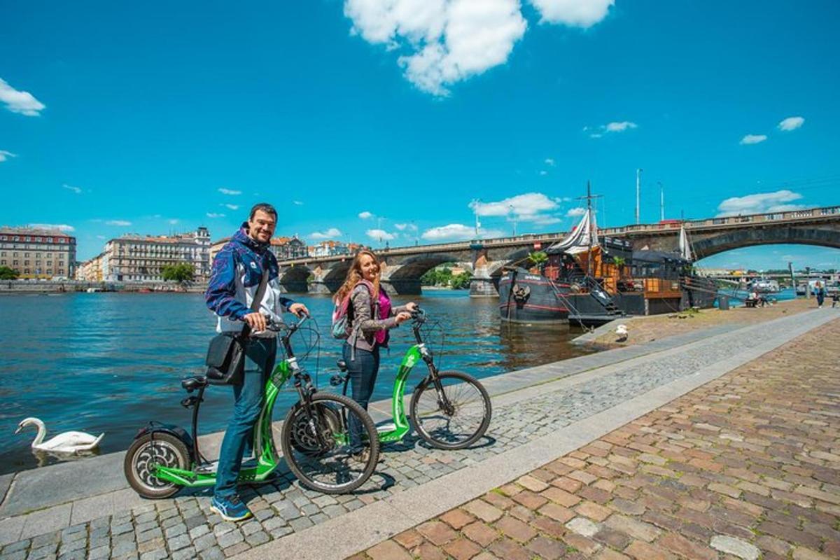 Un hombre y una mujer de pie con sus bicicletas en el río.