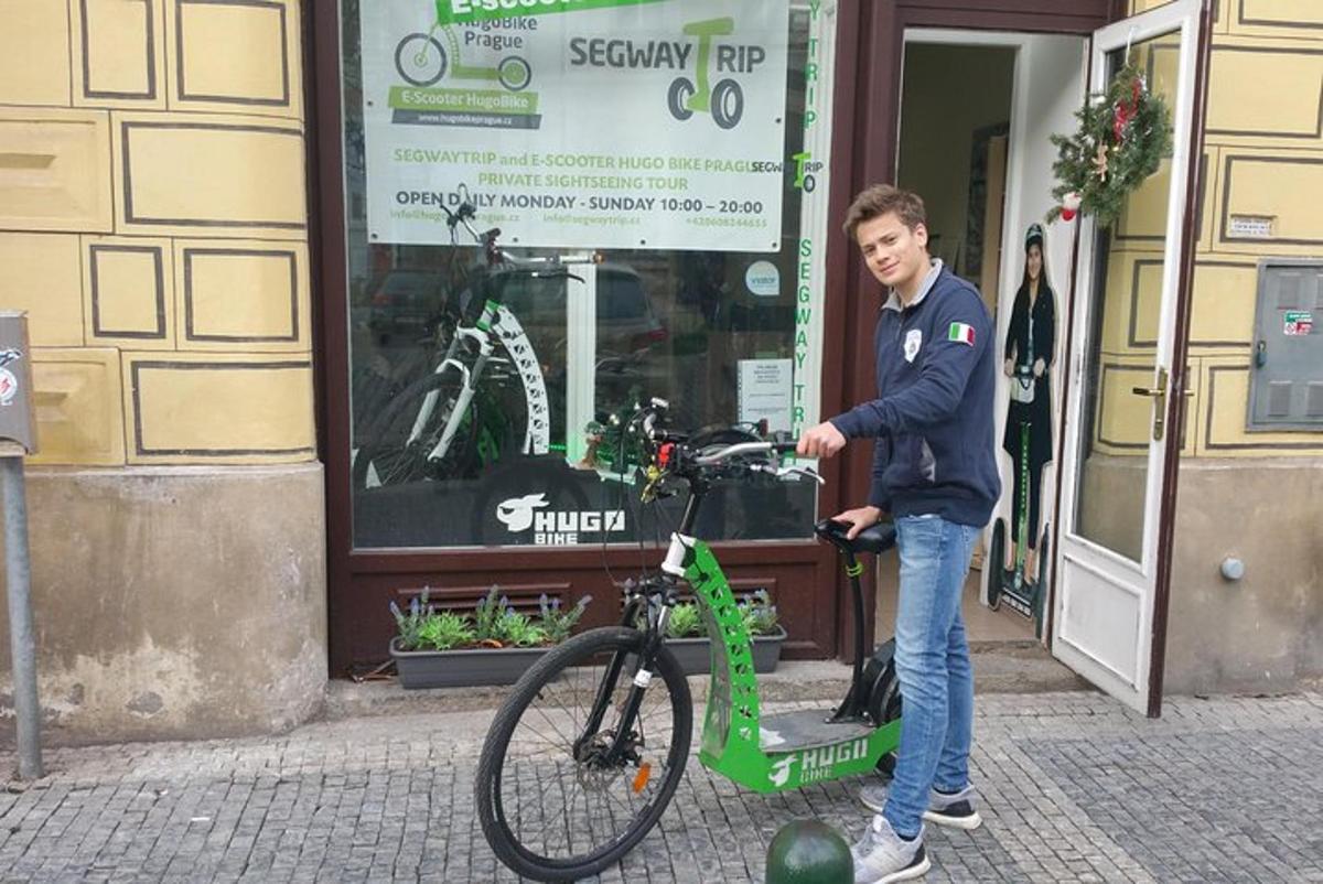 Un hombre está parado junto a una bicicleta verde.