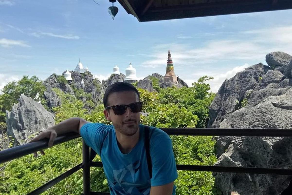 Egy férfi áll egy erkélyen, néhány szikla előtt