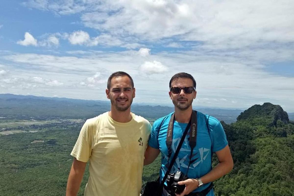 dois homens estão no topo de uma montanha