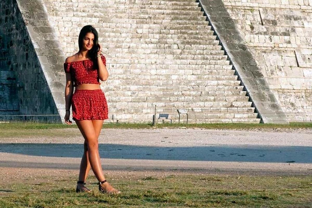 Una mujer con una falda roja parada frente a unos escalones.