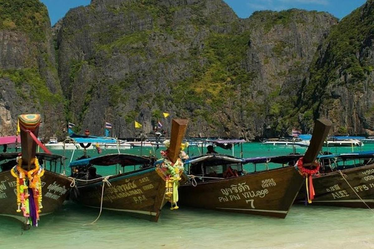 Un grupo de barcos estacionados en el agua cerca de una playa.