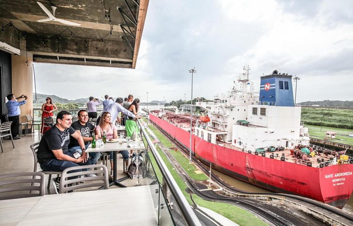 um grupo de pessoas sentadas à mesa em frente a um navio
