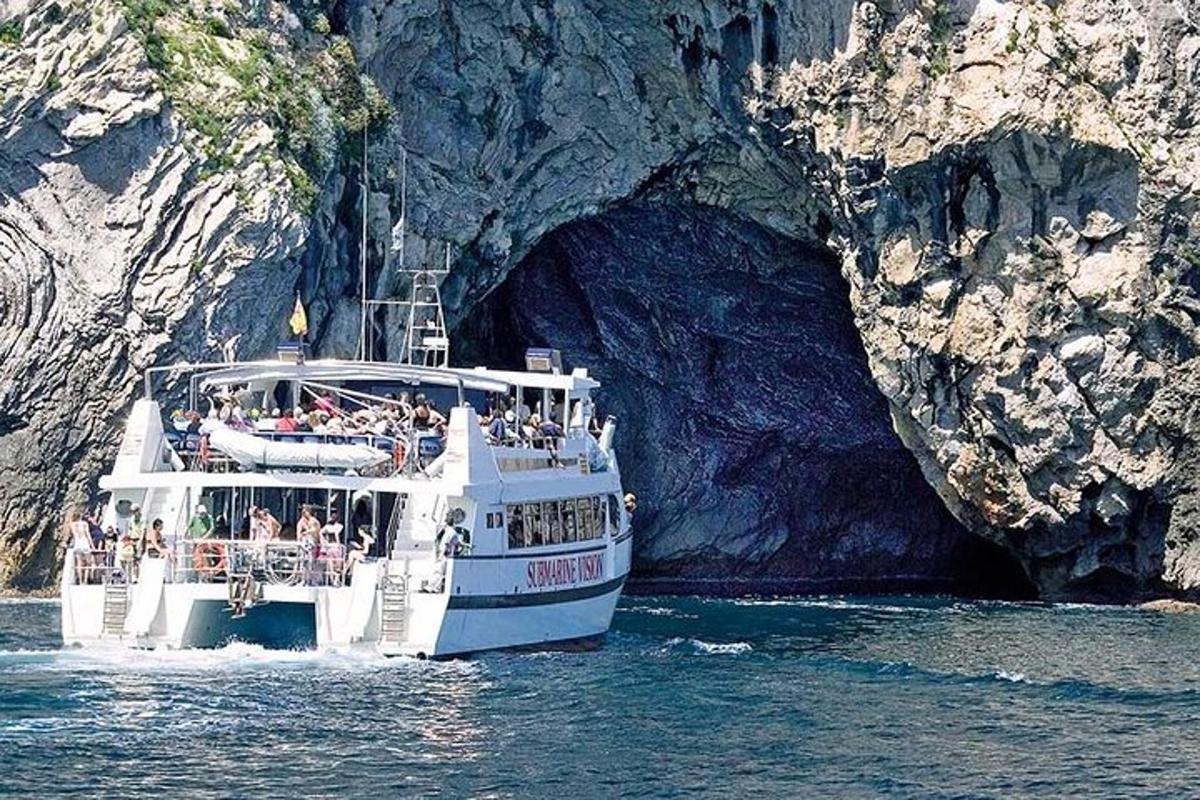 um barco branco na água perto de uma caverna