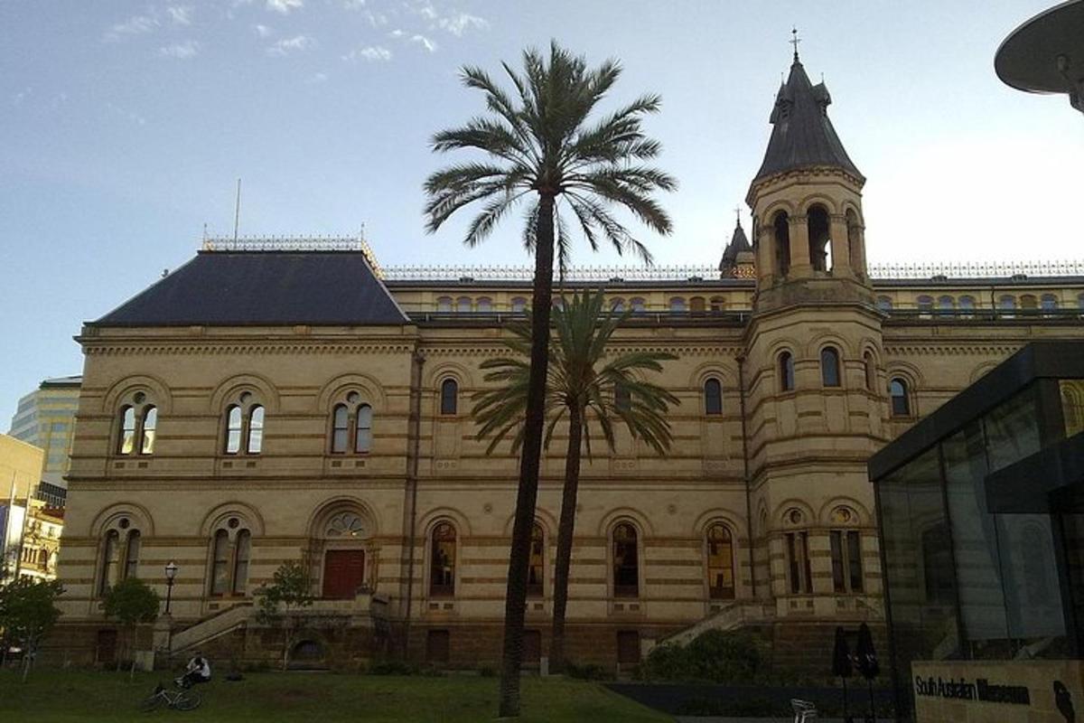 un grande edificio con una palma di fronte