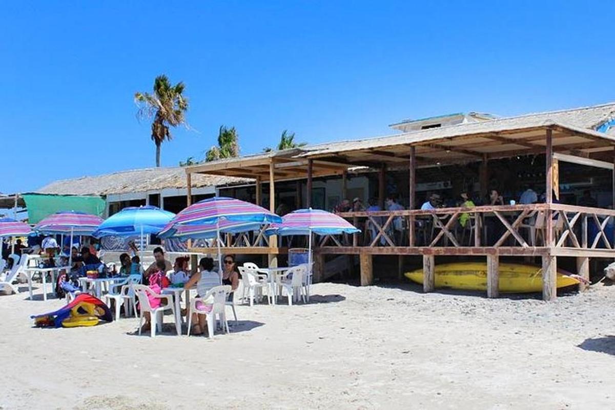 un gruppo di persone sedute sotto gli ombrelloni sulla spiaggia