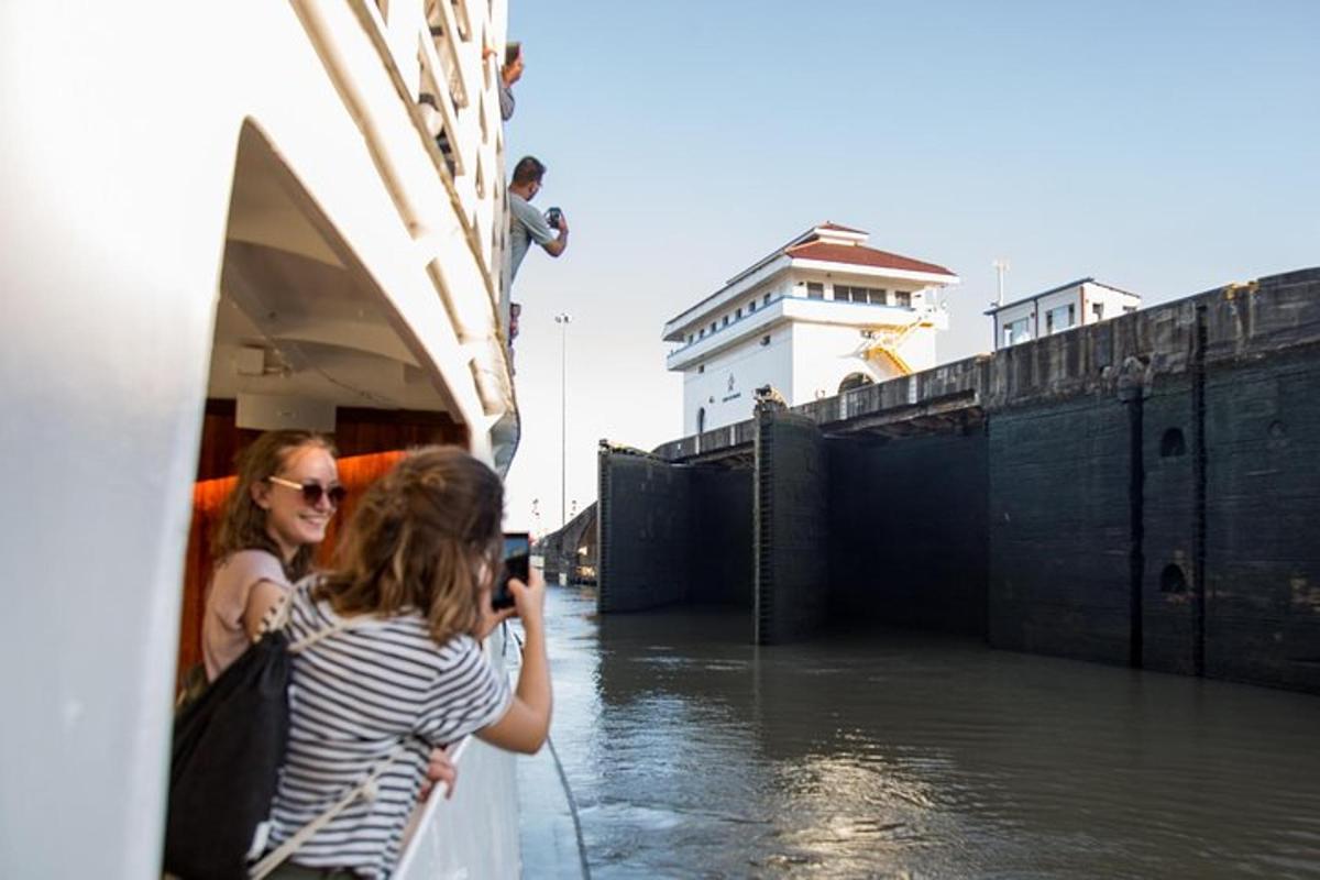 Una mujer tomando una fotografía de un barco en el agua.