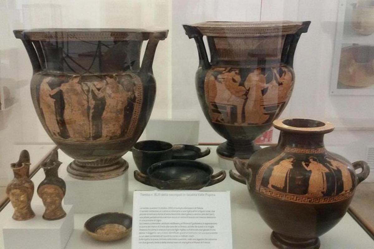 Una exhibición de jarrones y cuencos antiguos sobre una mesa.