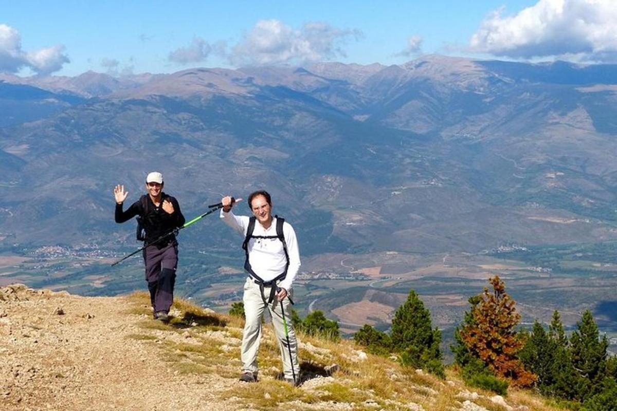 duas pessoas em pé no topo de uma montanha