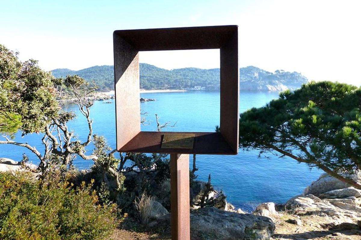 a mirror on a pole next to a body of water
