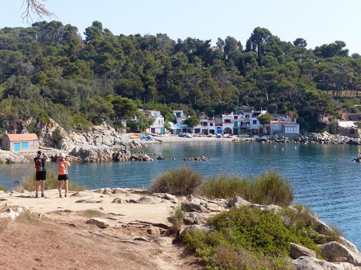 two people standing on a beach near a body of water