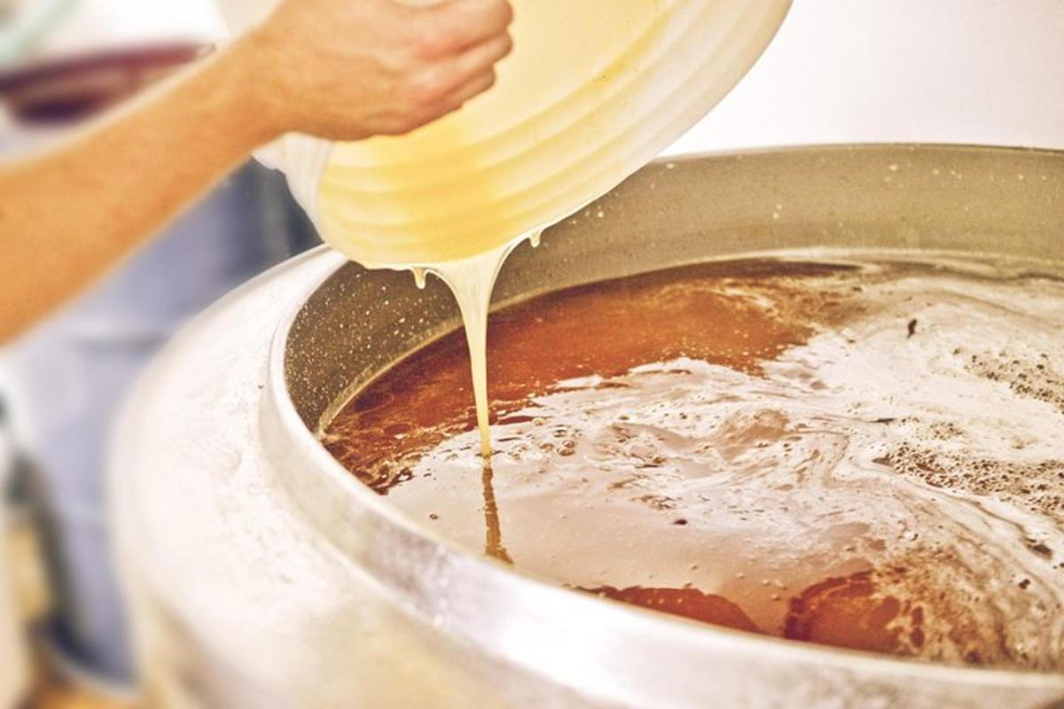 una persona està abocant llet en una olla de menjar
