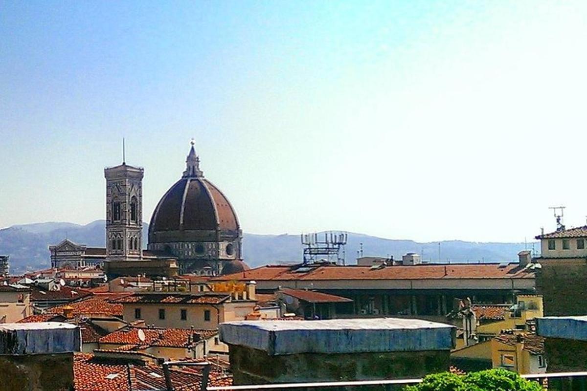 a view of a city with a cathedral and roofs