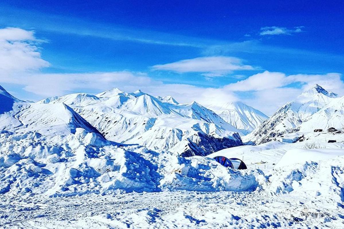 una montagna coperta di neve con montagne sullo sfondo