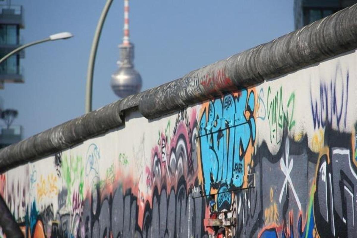 zeď s graffiti a věží v pozadí