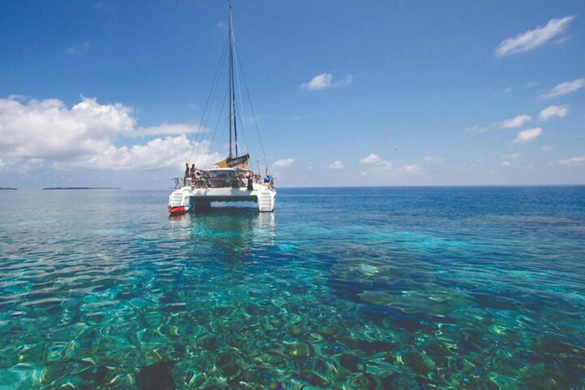 a boat floating in the ocean with crystal clear water