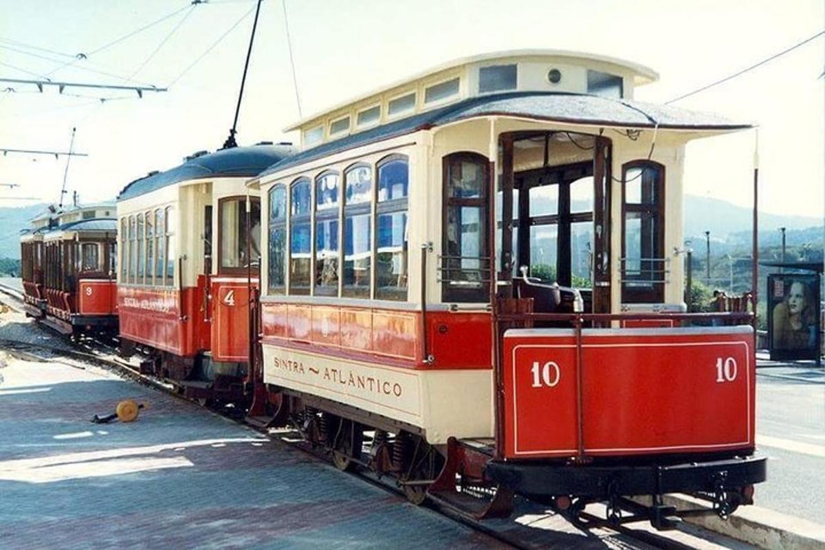 zwei rot-weiße Straßenbahnwagen stehen auf den Gleisen